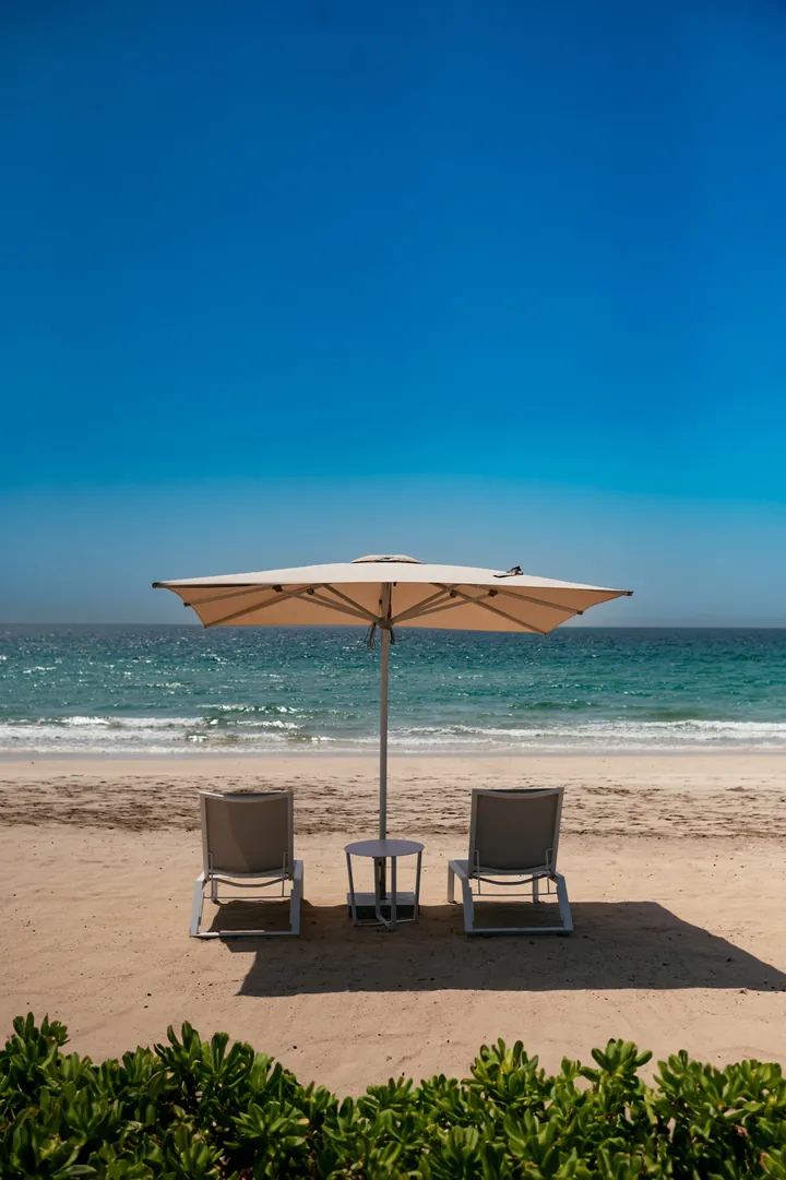 View photo: two loungers and a parasol facing the sea.