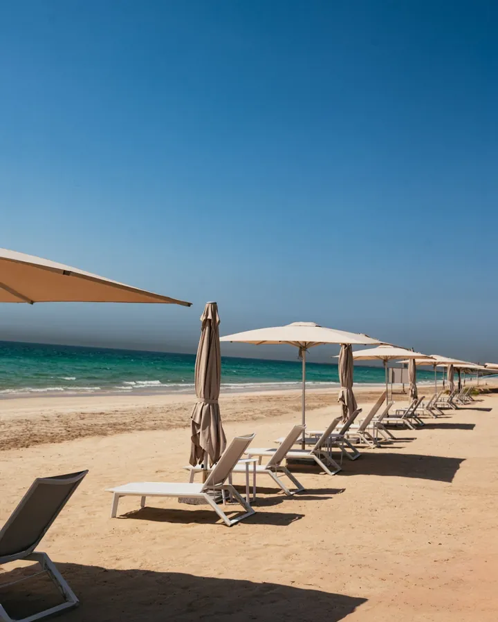 View photo: beachside seating and parasols.